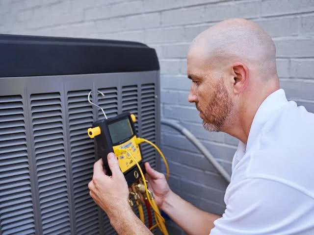Technician checking HVAC electrical components with a diagnostic meter